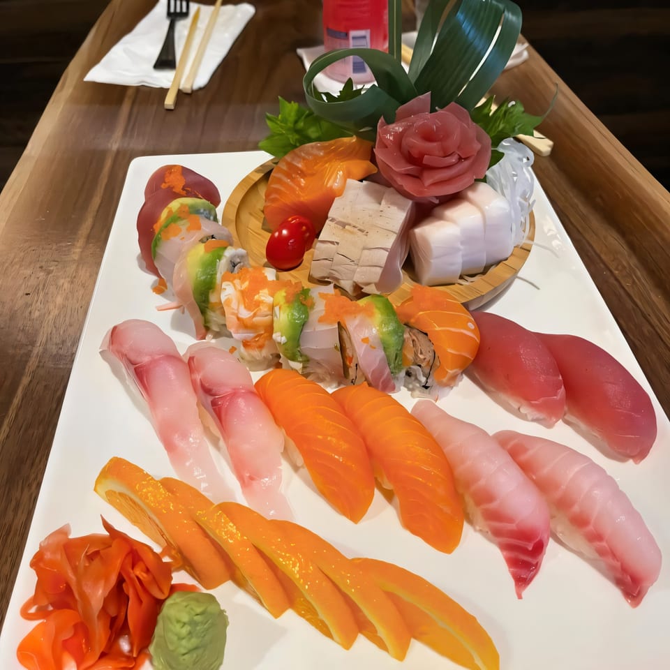 A large platter of Takara Sushi Station's colorful sushi, sashimi, and rolls on a wooden table.
